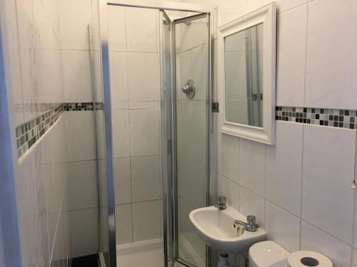 a bathroom with a shower and a sink and a mirror at Bourton House in Rugby