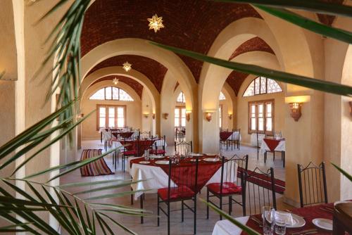 a restaurant with tables and chairs in a building at badawiya farafra hotel in Qasr Al Farafirah