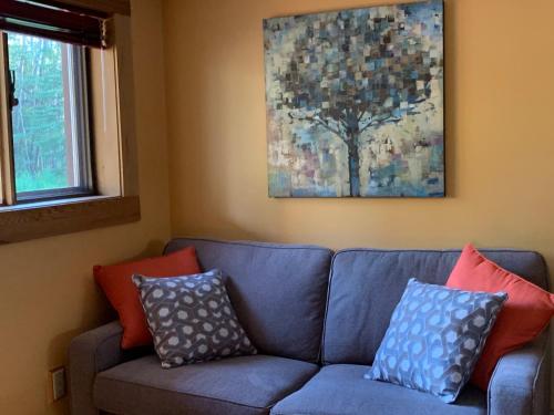 a living room with a blue couch with colorful pillows at Sawing Logzz Cabin in Copper Center