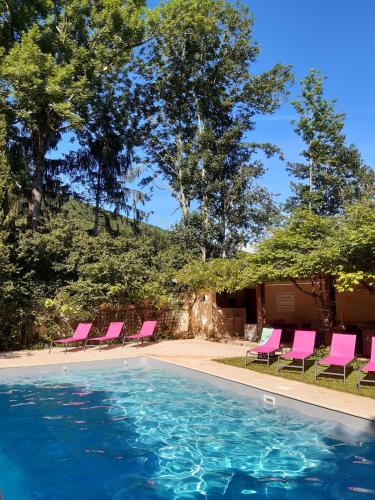a swimming pool with pink chairs and trees at Chambres d'Hôtes Domaine du Hameau Baylesse in Saint-Jean-dʼAigues-Vives
