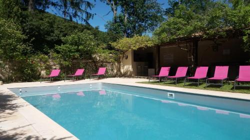 un grupo de sillas rosas y una piscina en Chambres d'Hôtes Domaine du Hameau Baylesse, en Saint-Jean-dʼAigues-Vives