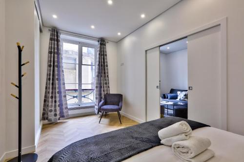 1 dormitorio con 1 cama, 1 silla y 1 ventana en 92 - Beautiful Apartment in Montorgueil, en París