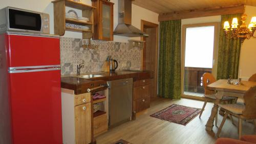 a kitchen with a red refrigerator and a table at s'Landhaus in Sankt Anton am Arlberg