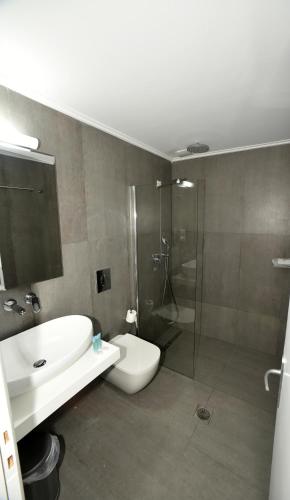a bathroom with a sink and a toilet and a shower at Olive Press Hotel in Mithymna