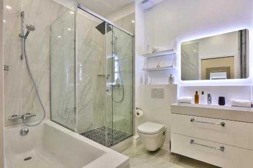 a white bathroom with a shower and a toilet at 92 - Beautiful Apartment in Montorgueil in Paris