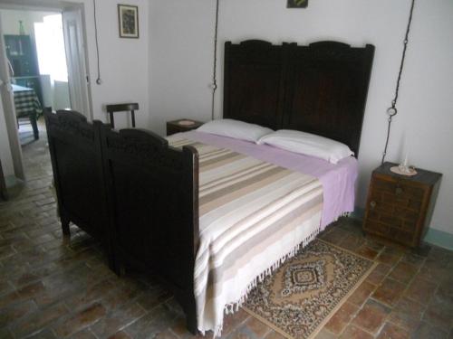 Schlafzimmer mit einem großen Bett mit einem Kopfteil aus Holz in der Unterkunft Don Pasquale Picciano- PESCARA-ABRUZZO in Picciano