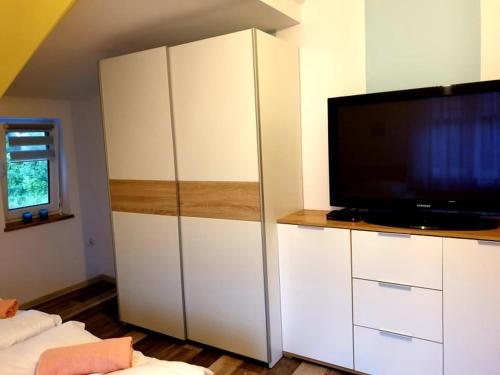 sala de estar con TV y armario blanco en B&B Villa Varmia en Frombork