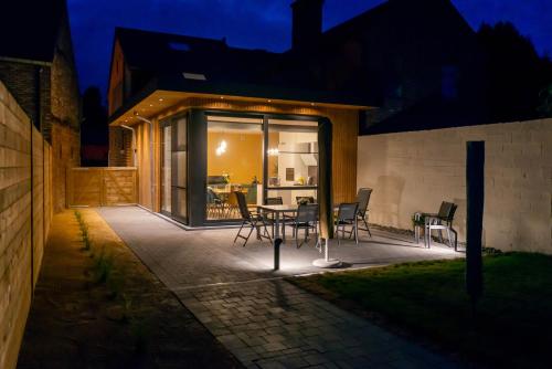 a patio with a table and chairs at night at De Lokroep in Heers