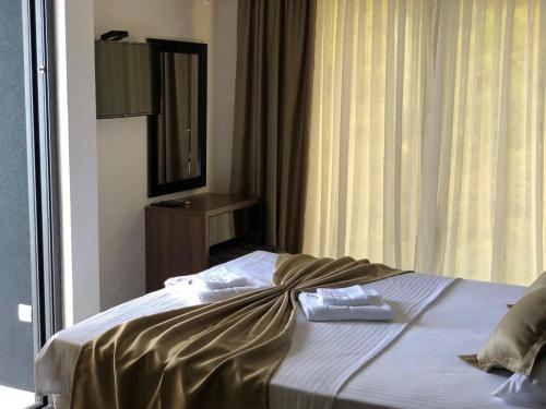 a bedroom with a bed with a mirror and a window at Apart Lux Beciragic in Dobra Voda
