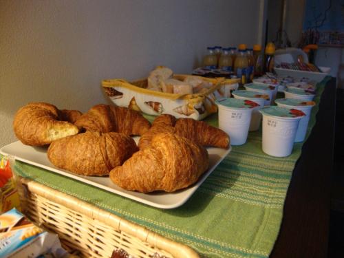einen Tisch mit einem Teller Croissants und anderem Gebäck in der Unterkunft La Buccetta B&B in Verona