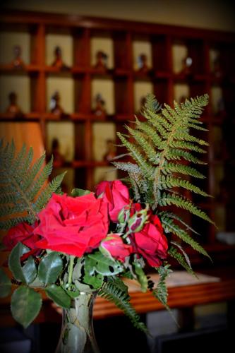 a vase filled with red roses sitting on a table at Hotel Capitán in Cangas de Onís