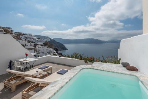 a swimming pool on a balcony with a view of the water at Chelidonia Luxury Suites in Oia