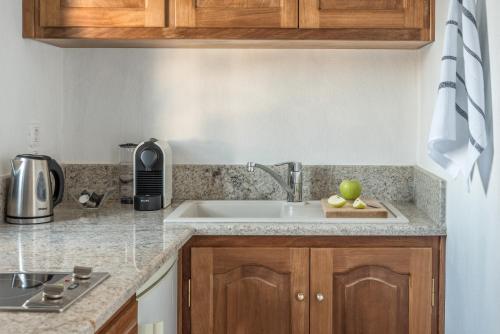 a kitchen with a sink and an apple on a cutting board at Chelidonia Luxury Suites in Oia