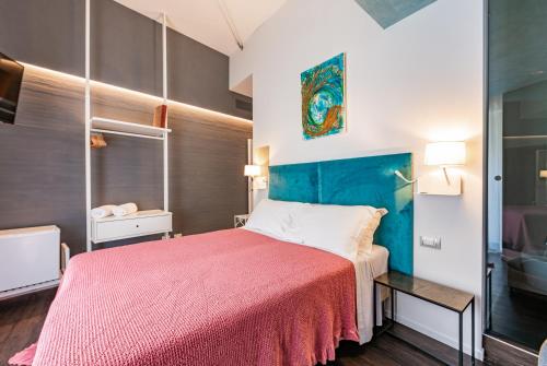 a bedroom with a bed with a red blanket at Sinestesia in Polignano a Mare