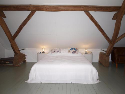 een slaapkamer met een groot wit bed met 2 lampen bij De Hoefstal 1765 in Asten