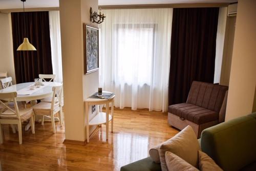 een woonkamer met een tafel en een bank bij Apartman Natalija Banja Luka in Banja Luka