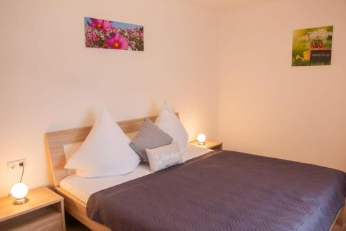 a bedroom with a bed with white sheets and pillows at Kleine-Perle in Dahme