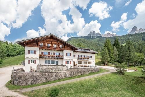 una casa en las montañas con una pared de piedra en Hotel Bewaller en Obereggen