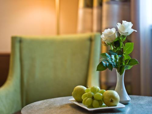 a vase filled with flowers on top of a table at Hotel König in Passau