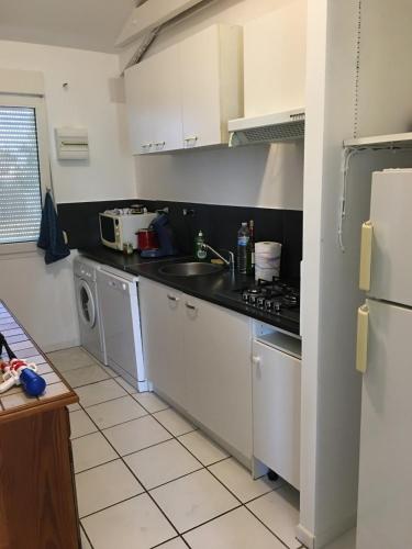 a kitchen with a sink and a stove at T3 WALIBI in Estillac