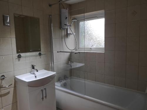 a bathroom with a sink and a tub and a shower at No. 9 in Swansea