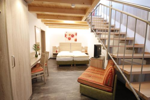 ein Zimmer mit einem Bett und einer Treppe mit einem Schlafzimmer in der Unterkunft Wirtshaus am Treidelpfad in Haßmersheim