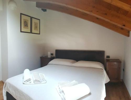 una camera con letto bianco e soffitto in legno di Appartamento Modenese 8 a Peschiera del Garda