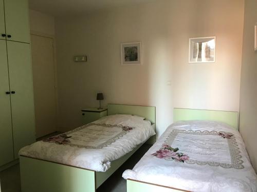 a bedroom with two beds and a night stand at KOKSIJDE BAD de block zeelaan B5 in Koksijde