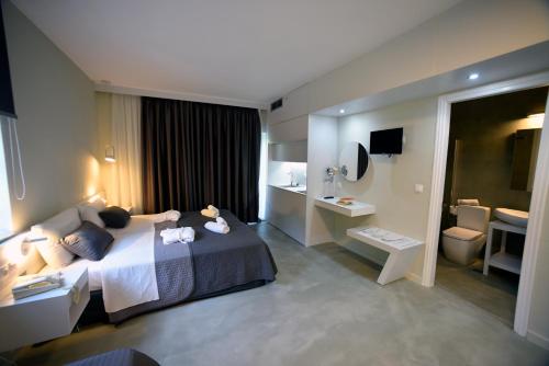 เตียงในห้องที่ Olive Press Hotel & Apartments