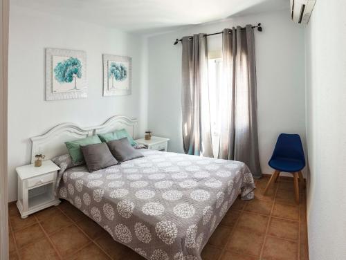 um quarto com uma cama e uma cadeira azul em Chalet en Matalascañas a 300 metros de la playa em Matalascañas