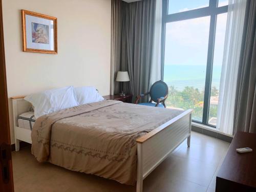 1 dormitorio con cama y ventana grande en Căn hộ Blue Sapphire en Vung Tau