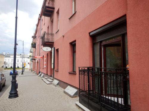 ピョートルクフ・トルィブナルスキにあるApartamenty Centrum z wanną dwuosobowąの道に鰹を持つピンクの建物
