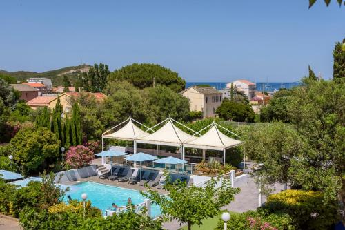 une vue aérienne d'une piscine avec des parasols dans l'établissement Hotel U Ricordu & Spa, à Macinaggio