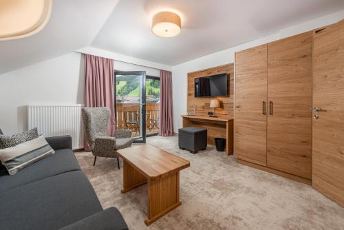 
a living room filled with furniture and a tv at Stadtvilla Schladming Boutiquehotel in Schladming
