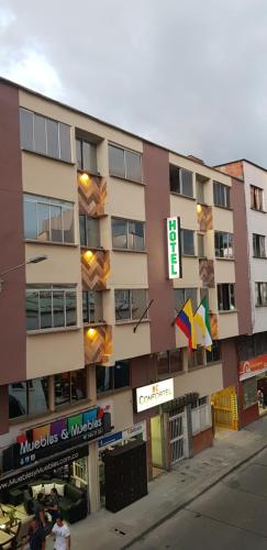 un edificio alto con un cartel delante en Hotel Confortel, en Armenia