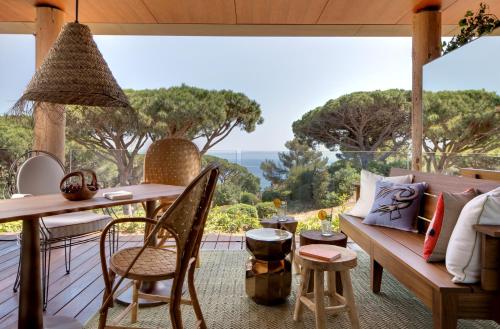a porch with a bench and a table with a view at Lily of the Valley in La Croix-Valmer