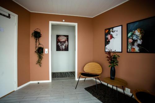a hallway with orange walls and a table and chairs at Floating Villa Bergen in Bergen