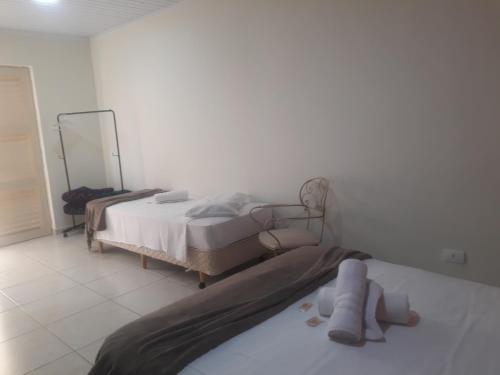 a bedroom with two beds and a mirror at Pousada Casa Doce Vida in Águas de Lindóia