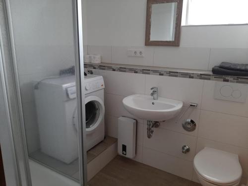 ein Badezimmer mit einer Waschmaschine und einem Waschbecken in der Unterkunft Ferienwohnung Wichtelgarten in Kranenburg