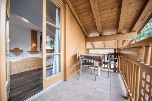 Cette chambre dispose d'un balcon avec une table et des chaises. dans l'établissement Hotel Rosenheim, à Racines