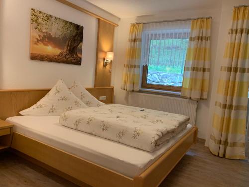 ein kleines Schlafzimmer mit einem Bett und einem Fenster in der Unterkunft Ferienwohnungen Eiter Fridolin in Zaunhof