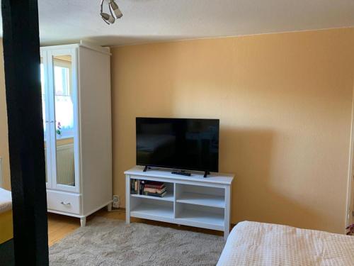 a bedroom with a flat screen tv on a white cabinet at Gästehaus Windheim (Karlsruher Denkmal) in Karlsruhe