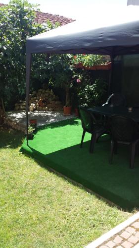 a green lawn with a table under a tent at Apartament Stonel in Veliko Tŭrnovo