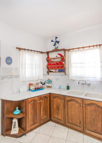a kitchen with wooden cabinets and a sink at Luxury Wave Maisonette in Istérnia