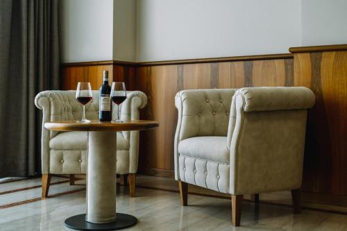 two chairs and a table with two glasses of wine at Hotel Panoramic in Giardini Naxos