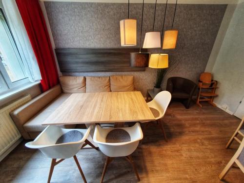 a dining room with a wooden table and chairs at Komfort Ferienwohnungen Zwenkauer See in Zwenkau
