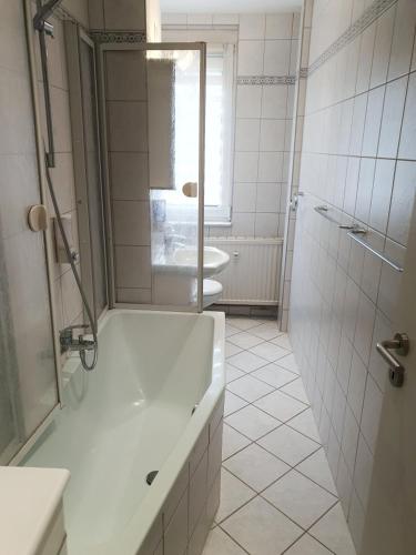 a bathroom with a tub and a sink and a toilet at Komfort Ferienwohnungen Zwenkauer See in Zwenkau