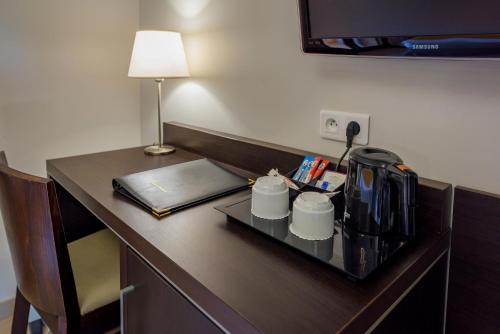 a desk with a coffee mug and a computer at Hotel U Ricordu & Spa in Macinaggio