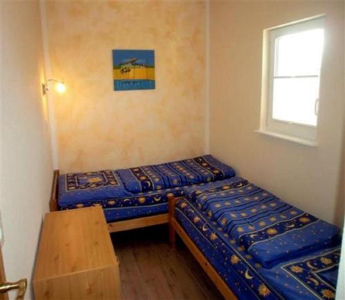 ein kleines Zimmer mit 2 Betten und einem Fenster in der Unterkunft Ferienwohnung Magdalena in Hohnstein