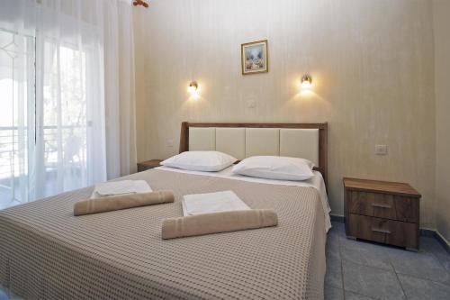 a bedroom with a large bed with two pillows on it at FunBeach Rooms in Neos Marmaras